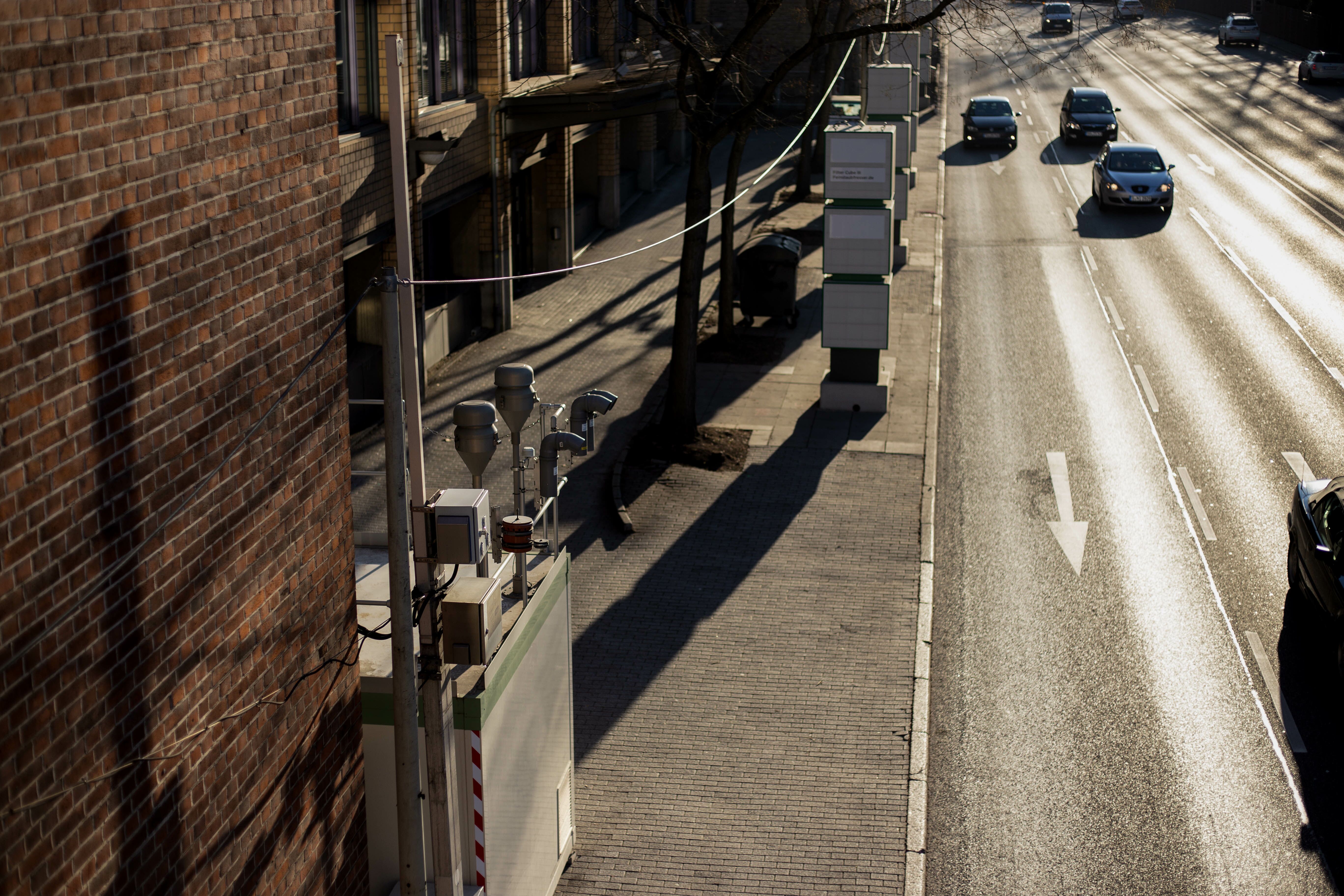 A bustling city street with heavy traffic flow, featuring Palas devices diligently positioned on the side, actively monitoring and ensuring urban air quality.