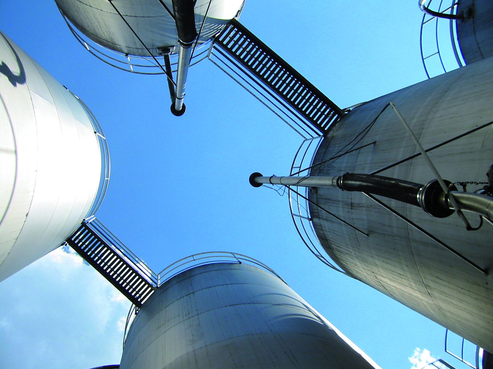 Upward perspective capturing four large chimneys on a landfill site emitting emissions and fine dust. Palas offers diverse solutions for monitoring and addressing air quality challenges.