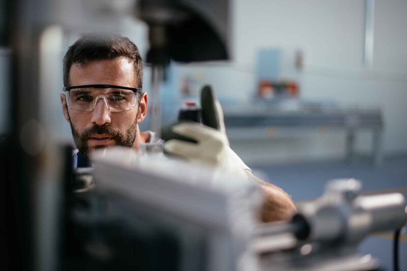 A man wearing safety glasses and gloves holds a Palas® measuring device. Both the products and customer service of Palas guarantee high-quality standards and finding the optimal solution for every customer.