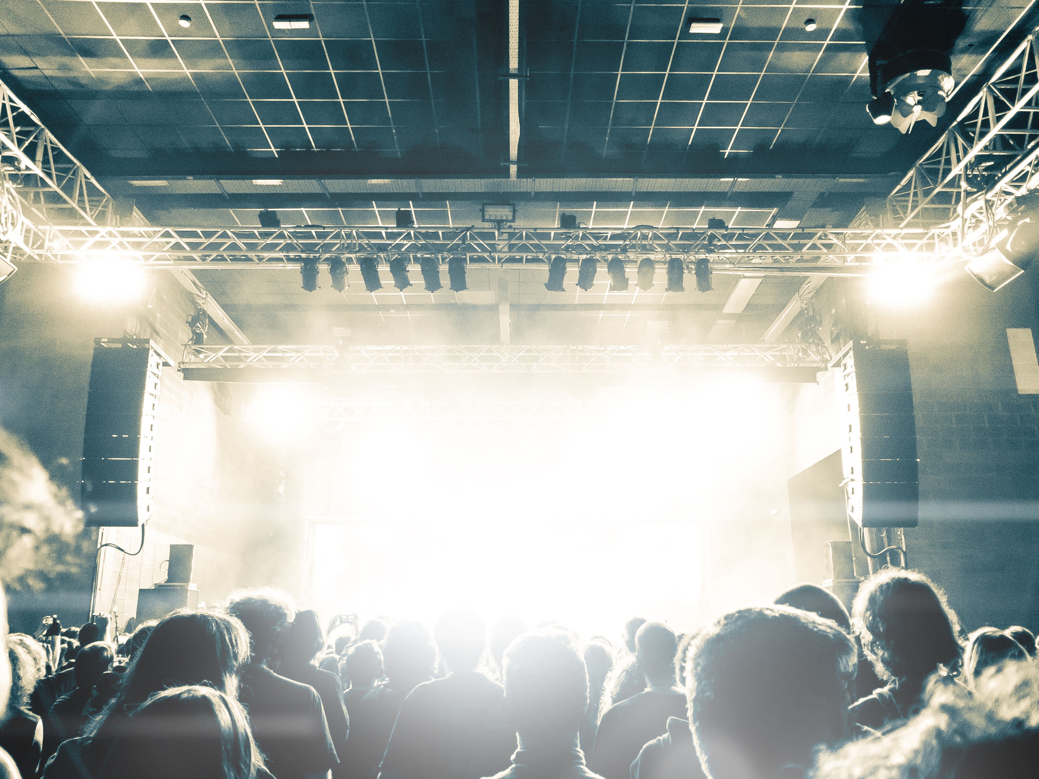 A moment of heightened anticipation as individuals stand in front of a stage, illuminated by bright headlights, eagerly waiting to learn about Palas' cutting-edge technology.