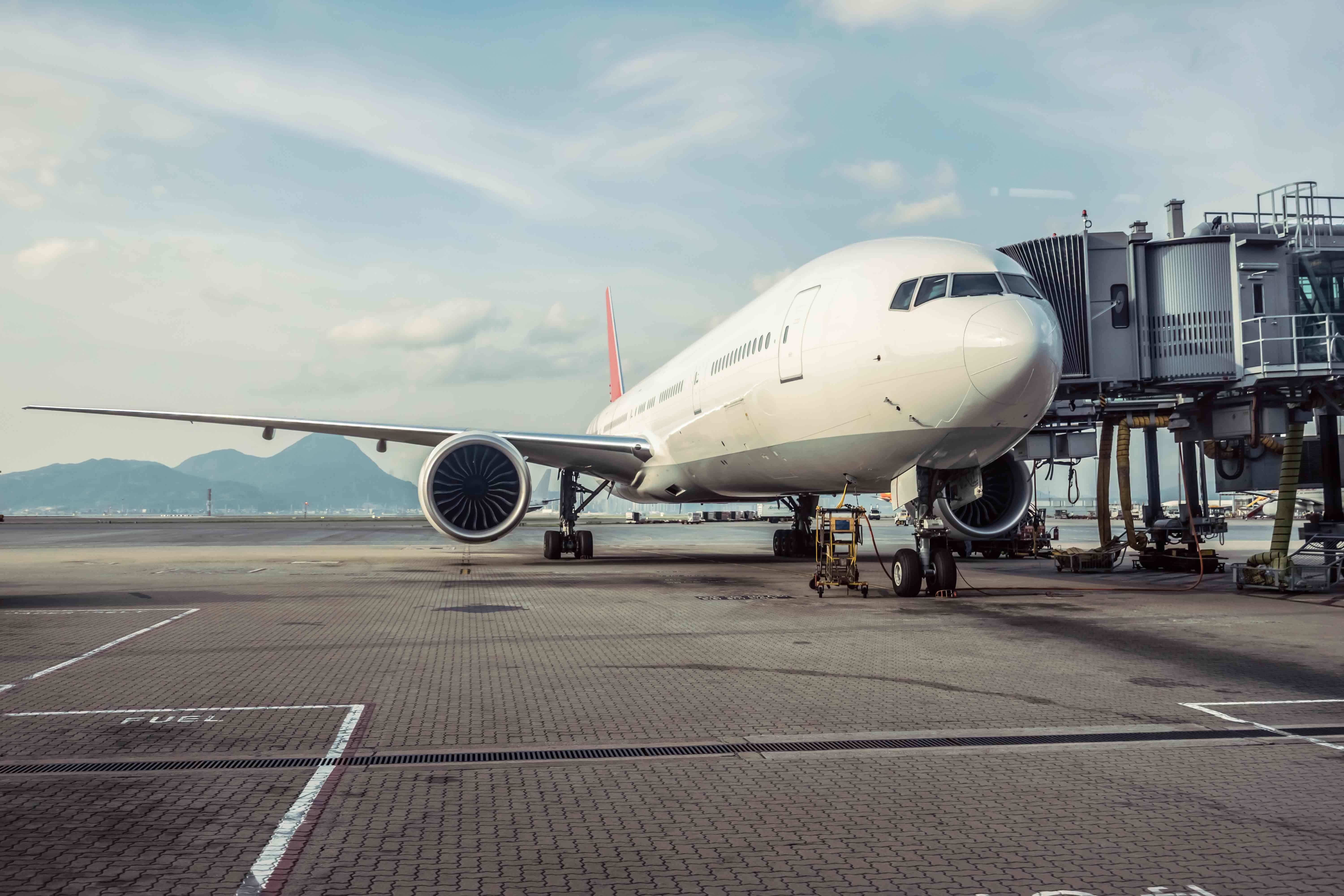 Intriguing scene of an airplane on a runway, set against a backdrop of majestic mountains. Palas contributes to environmental awareness by monitoring ultrafine dust generated by air traffic.