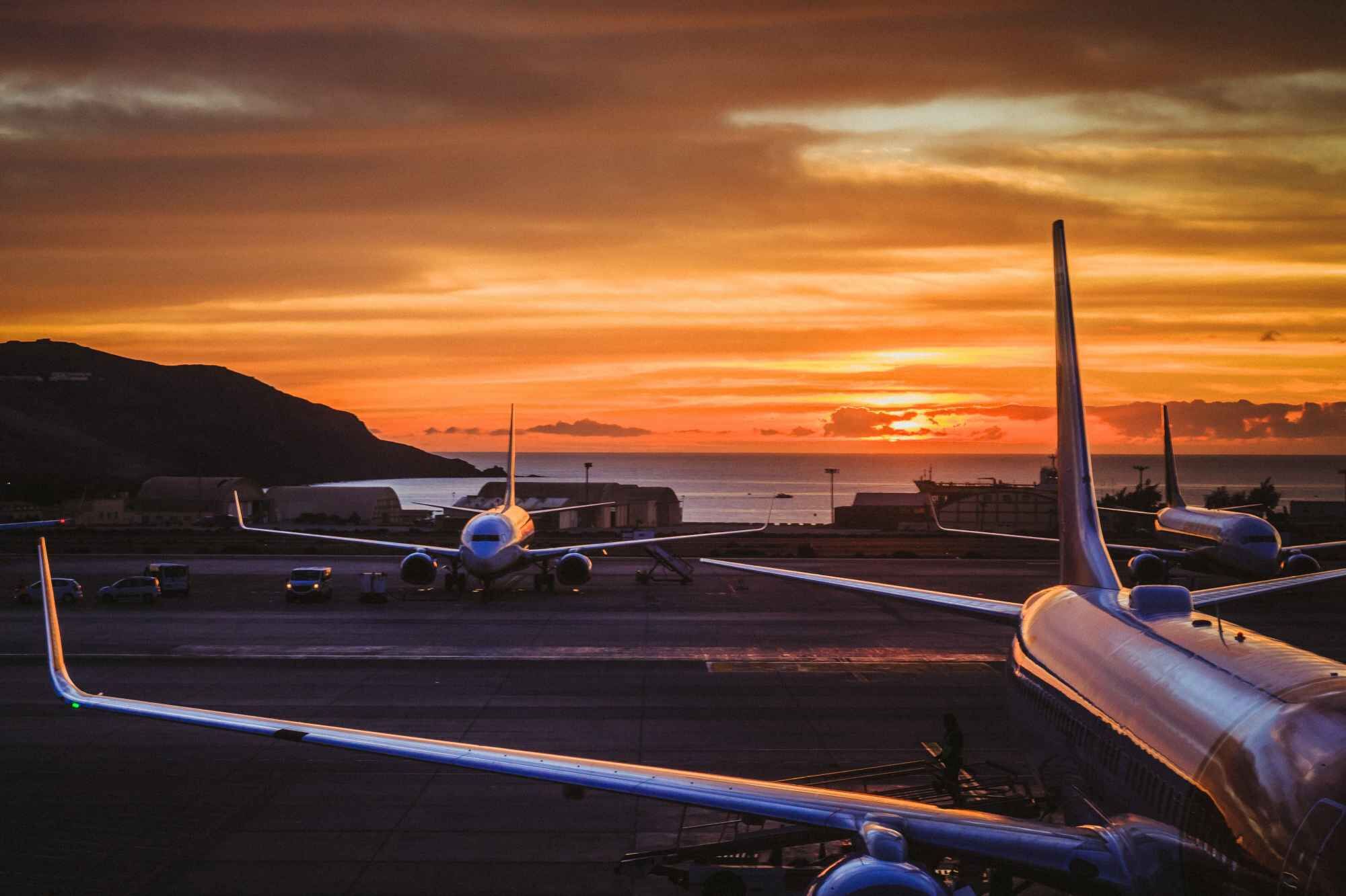 An airport with three planes during sunset. Palas&reg; devices allow the accurate measurement of particle concentration and size related to environmental and industrial processes, for instance regarding air pollution and air quality at airports.