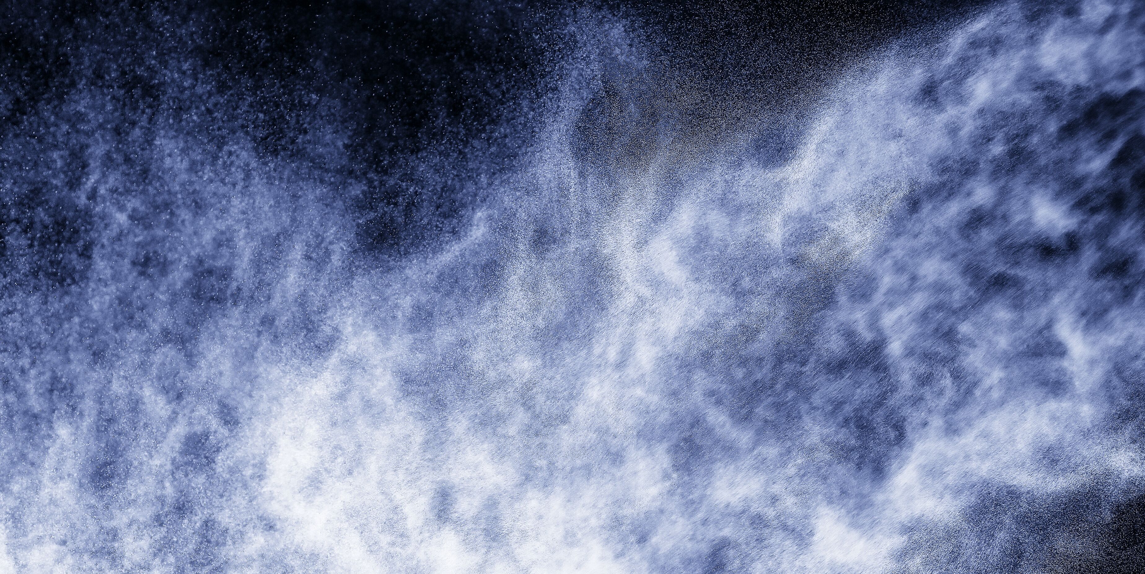 Dynamic image capturing white aerosols moving against a black background, creating a mesmerizing and abstract visual display.