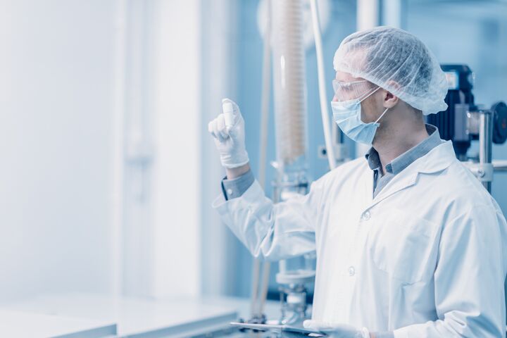 Dedicated scientist wearing protective gear while meticulously examining a laboratory sample, emphasizing precision and attention to detail in the pursuit of scientific discovery.